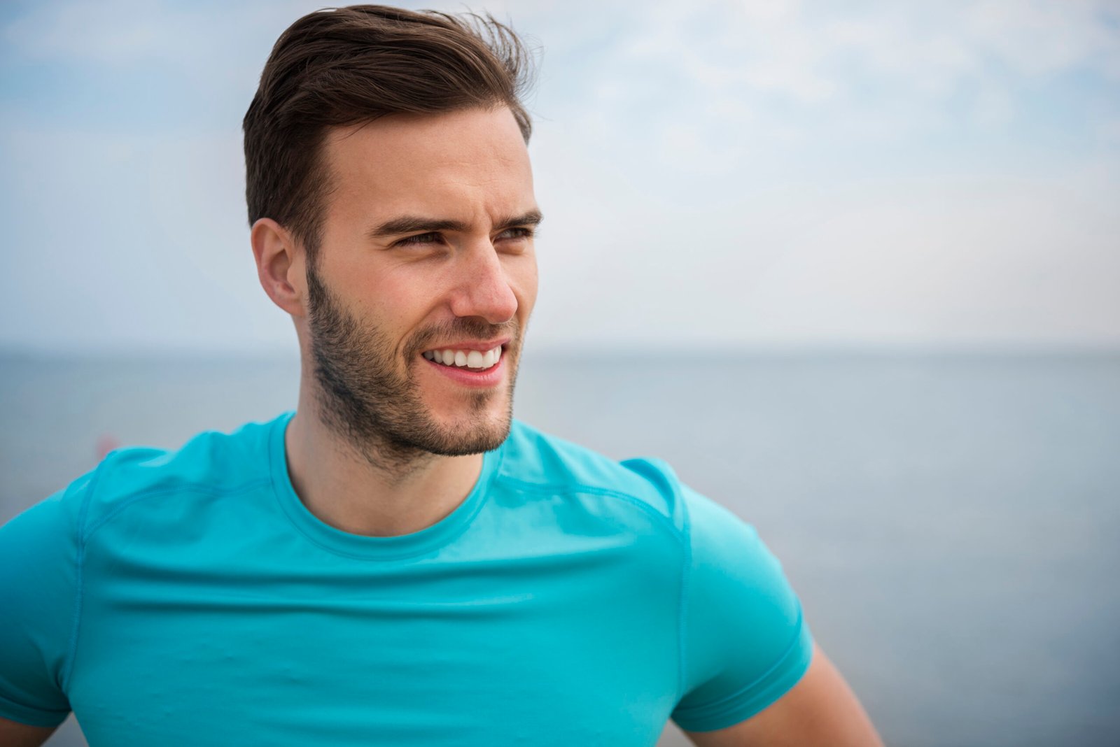 close up young fit person jogging by sea scaled