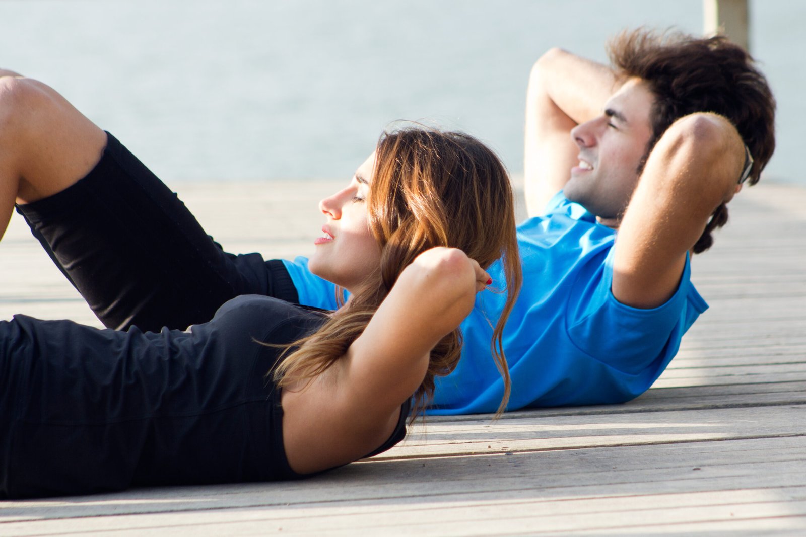 couple doing push ups near sea scaled